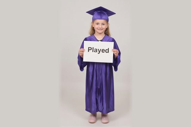 Graduate in cap and gown holding a word card: Played