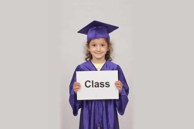 Graduate in cap and gown holding a word card: Class