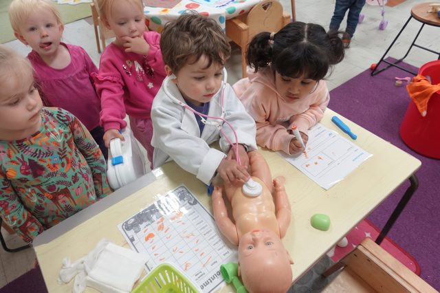 Children playing doctors with a baby doll